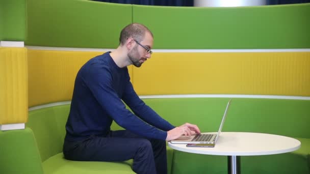 Mann mit Brille arbeitet am Laptop — Stockvideo