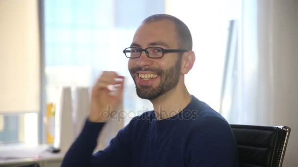 El hombre con gafas sonríe y ríe — Vídeos de Stock