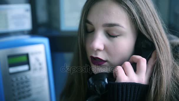 Όμορφη νεαρή γυναίκα μιλώντας στον τηλεφωνικό θάλαμο — Αρχείο Βίντεο