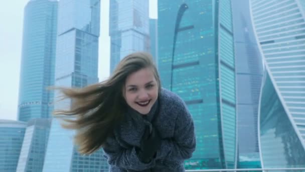 Девушка позирует на фоне небоскреба — стоковое видео