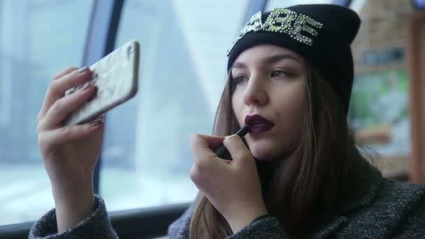 Chica lápiz labial mirando el teléfono — Vídeos de Stock