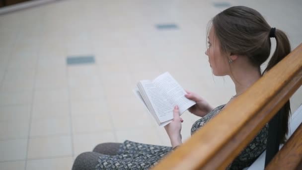 Νεαρή κοπέλα που διαβάζει ένα βιβλίο — Αρχείο Βίντεο