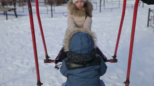 Crianças balançando em um balanço câmera lenta — Vídeo de Stock