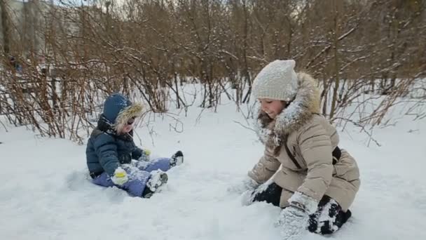 Crianças brincando na neve câmera lenta — Vídeo de Stock