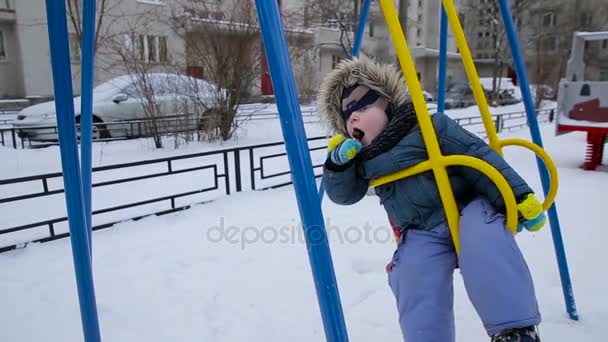 Мальчик качается на качелях — стоковое видео