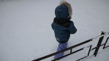 Küçük çocuk kar üzerinden çalışan