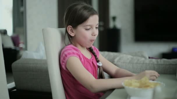 Liten flicka äter potatis chips — Stockvideo