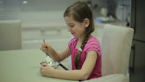 Girl eating ice cream in the kitchen — Stock Video