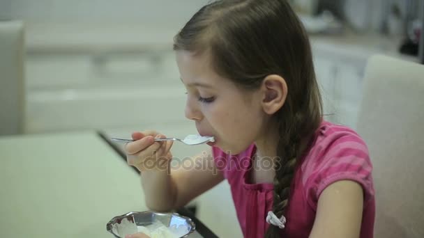 Lány eszik fagylaltot a konyhában — Stock videók