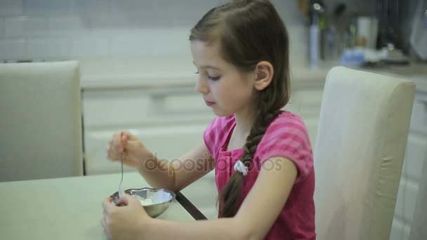 Девушка ест мороженое на кухне — стоковое видео