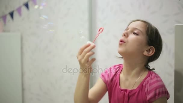 Little girl blows soap bubbles — Stockvideo