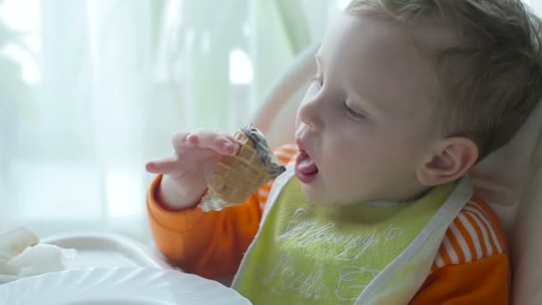 O rapazinho está a comer gelado. — Vídeo de Stock