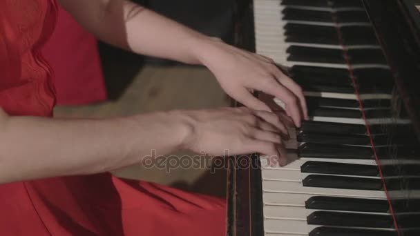 Una ragazza che suona al pianoforte in abito rosso — Video Stock