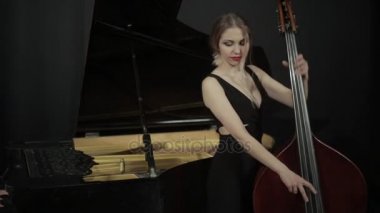 Siyah dreess kontrbas üzerinde oynayan kız