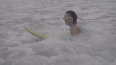 Sahilde sarı surfboard ile güzel kadın