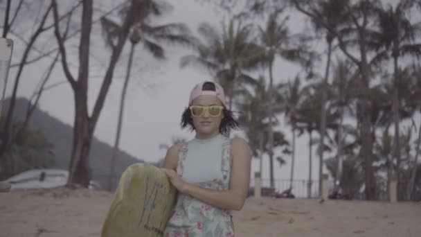 Bella donna con tavola da surf gialla sulla spiaggia — Video Stock