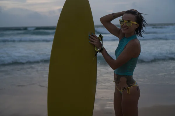 Schöne Frau mit gelbem Surfbrett am Strand — Stockfoto