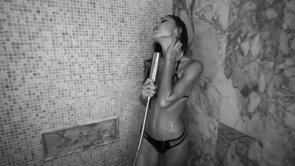 Kvinna i bikini tar dusch efter spa-behandlingar — Stockvideo