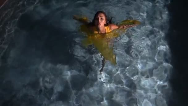 Mulher morena bonita vestindo vestido amarelo na piscina — Vídeo de Stock