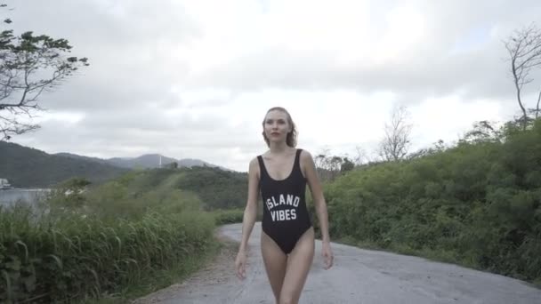 Красива жінка ходить в чорному купальнику — стокове відео