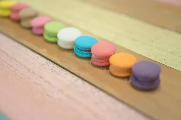 Multicolored macaroons on white wooden background — Stock Photo, Image