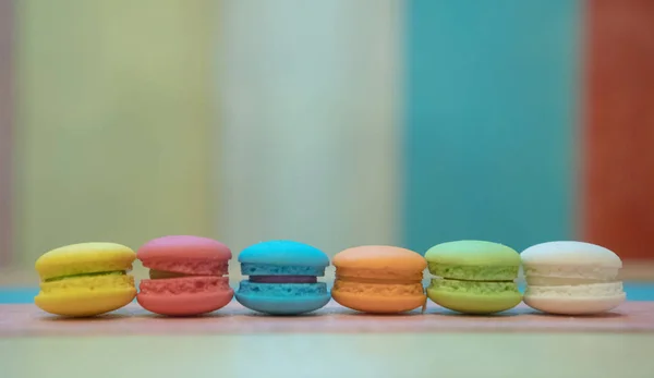 Macaroons multicoloridos em fundo de madeira branca — Fotografia de Stock