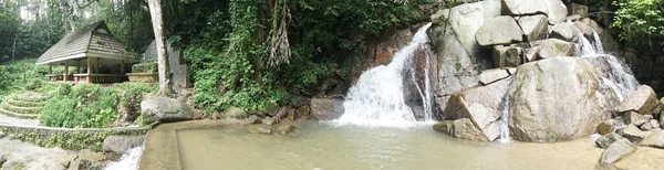 Kleine berg waterval op de rotsen en gezellige alkoof vijand ontspannen in het tropische bos — Stockfoto