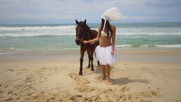Vrouw met bruin paard op het strand — Stockvideo