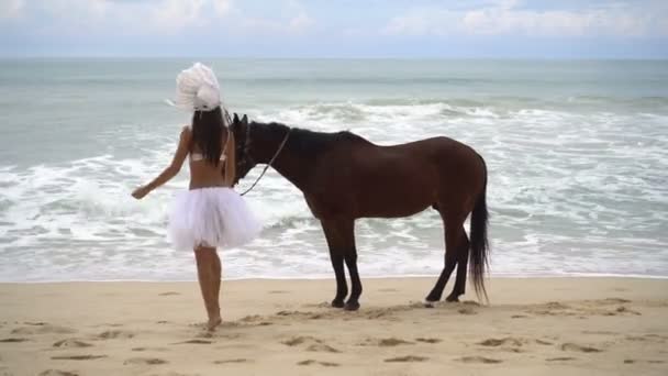 Vrouw met bruin paard op het strand — Stockvideo