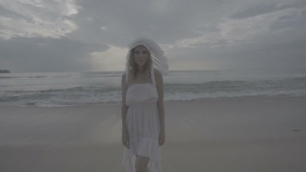 Γυναίκα με λευκό φτερό ινδικό καπέλο στην παραλία — Αρχείο Βίντεο