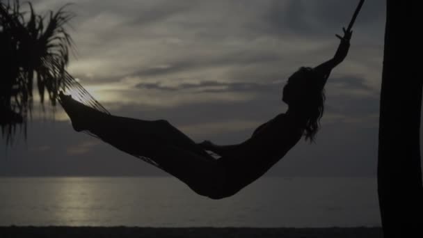 Женщина в гамаке на пляже — стоковое видео