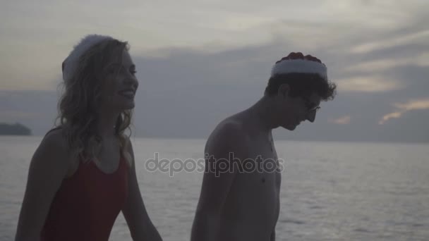 Пара в шляпе Санты на пляже — стоковое видео