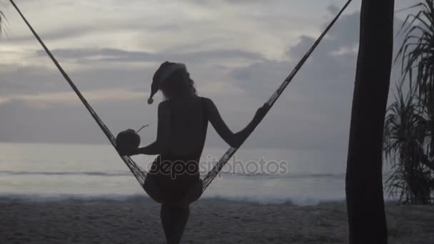 Frau mit Weihnachtsmütze am Strand — Stockvideo