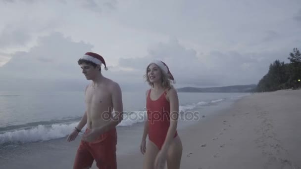 Coppia con cappello da Babbo Natale in spiaggia — Video Stock