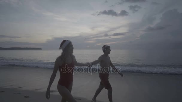 Coppia con cappello da Babbo Natale in spiaggia — Video Stock