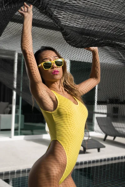 Sexy woman in yellow swimsuit at swimming pool — Stock Photo, Image