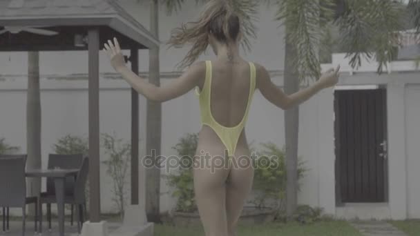 Sexy woman in yellow swimsuit at swimming pool — Stock Video