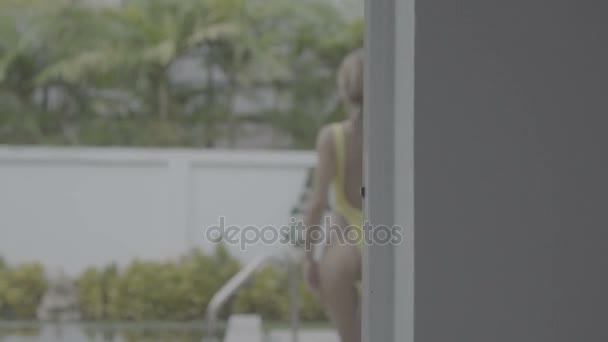 Femme sexy en maillot de bain jaune à la piscine — Video