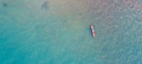 Вид с воздуха на пришвартованную рыбацкую лодку в морских водах Пхукета
