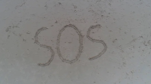 Ovanifrån foto av Sos skrivet i sand på tropical beach — Stockfoto
