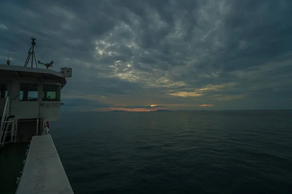 Barco navegando em dia tempestuoso nublado durante o belo pôr do sol — Fotografia de Stock