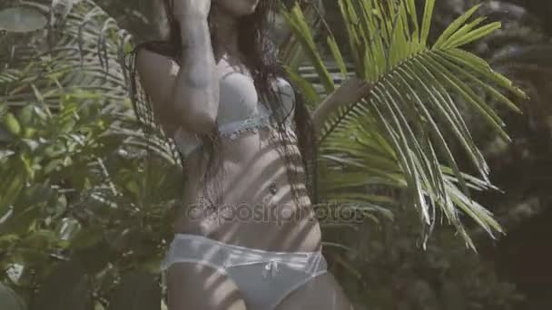Vacker brunett kvinna mellan palmer — Stockvideo
