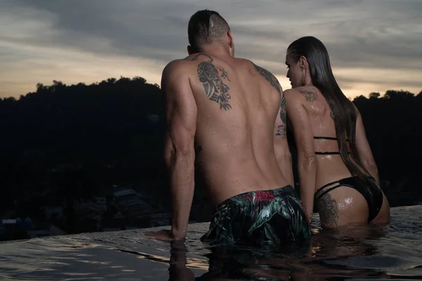 Casal romântico sozinho na piscina infinita — Fotografia de Stock