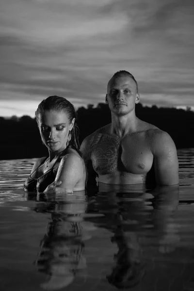 Romantic couple alone in infinity swimming pool — Stock Photo, Image