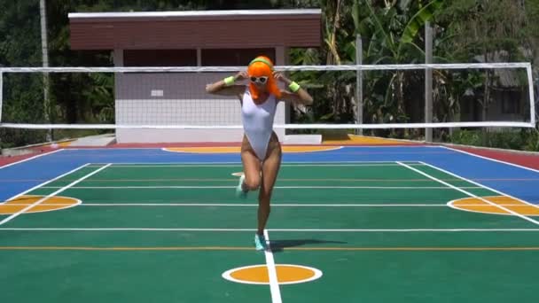 Woman in white swimsuit and orange wig — Stock Video