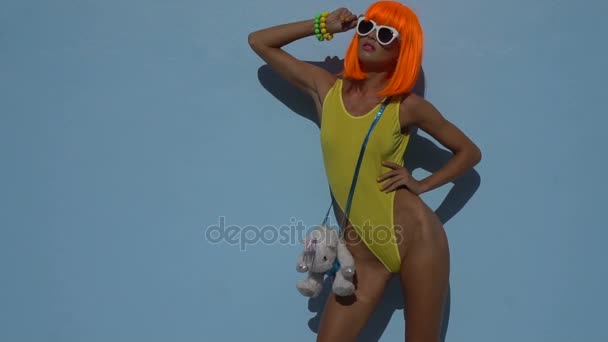Mujer en traje de baño amarillo y peluca naranja — Vídeo de stock