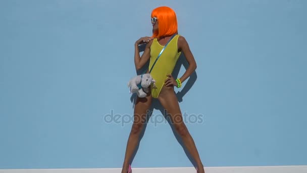 Mujer en traje de baño amarillo y peluca naranja — Vídeos de Stock