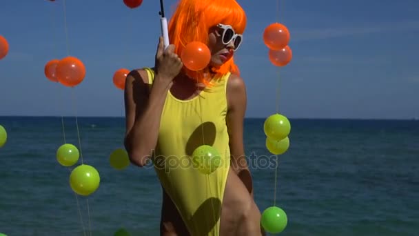 Woman in yellow swimsuit and orange wig — Stock Video