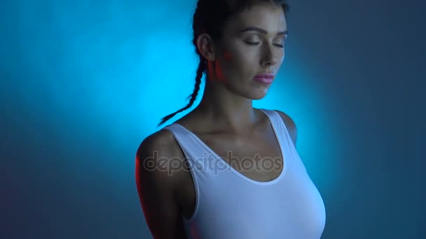 Close-up rosto e parte superior do corpo de mulher morena bonita em maiô branco posando na câmera em estúdio — Vídeo de Stock