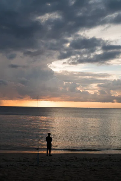 Człowiek stojący na plaży nad morze i zachód słońca niebo tło — Zdjęcie stockowe
